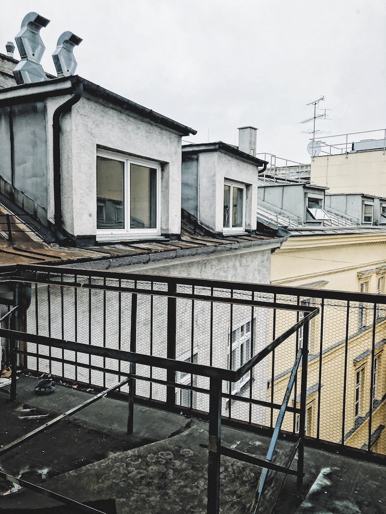 Blick auf eine Häuserwand und grauem Himmel.